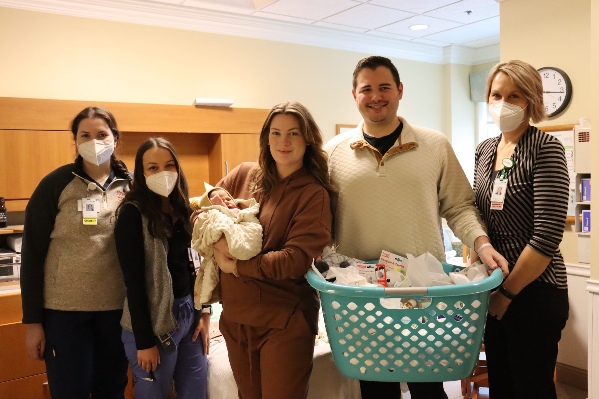 Amy Austin (right) of the LRH Auxiliary presents new parents, Chelsey and Brad, and newborn Scarlett (center), with a basket of baby items.